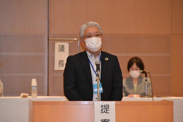理事会を代表して挨拶する安達理事長